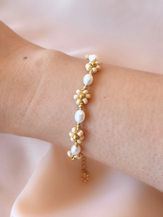 August Pearl Bracelet made of premium Japanese seed bead daisies and freshwater pearls, shown worn on a wrist.
