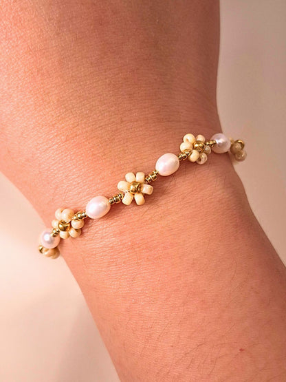 August Pearl Bracelet made of premium Japanese seed bead daisies and freshwater pearls, shown worn on a wrist.
