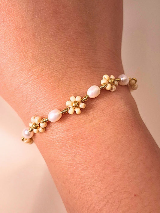 August Pearl Bracelet made of premium Japanese seed bead daisies and freshwater pearls, shown worn on a wrist.