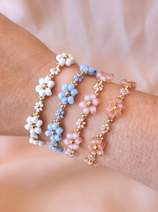 A stack of four Dear Daisy flower bracelets in multiple pastel colors, made of premium Japanese seed beads, shown worn on a wrist.