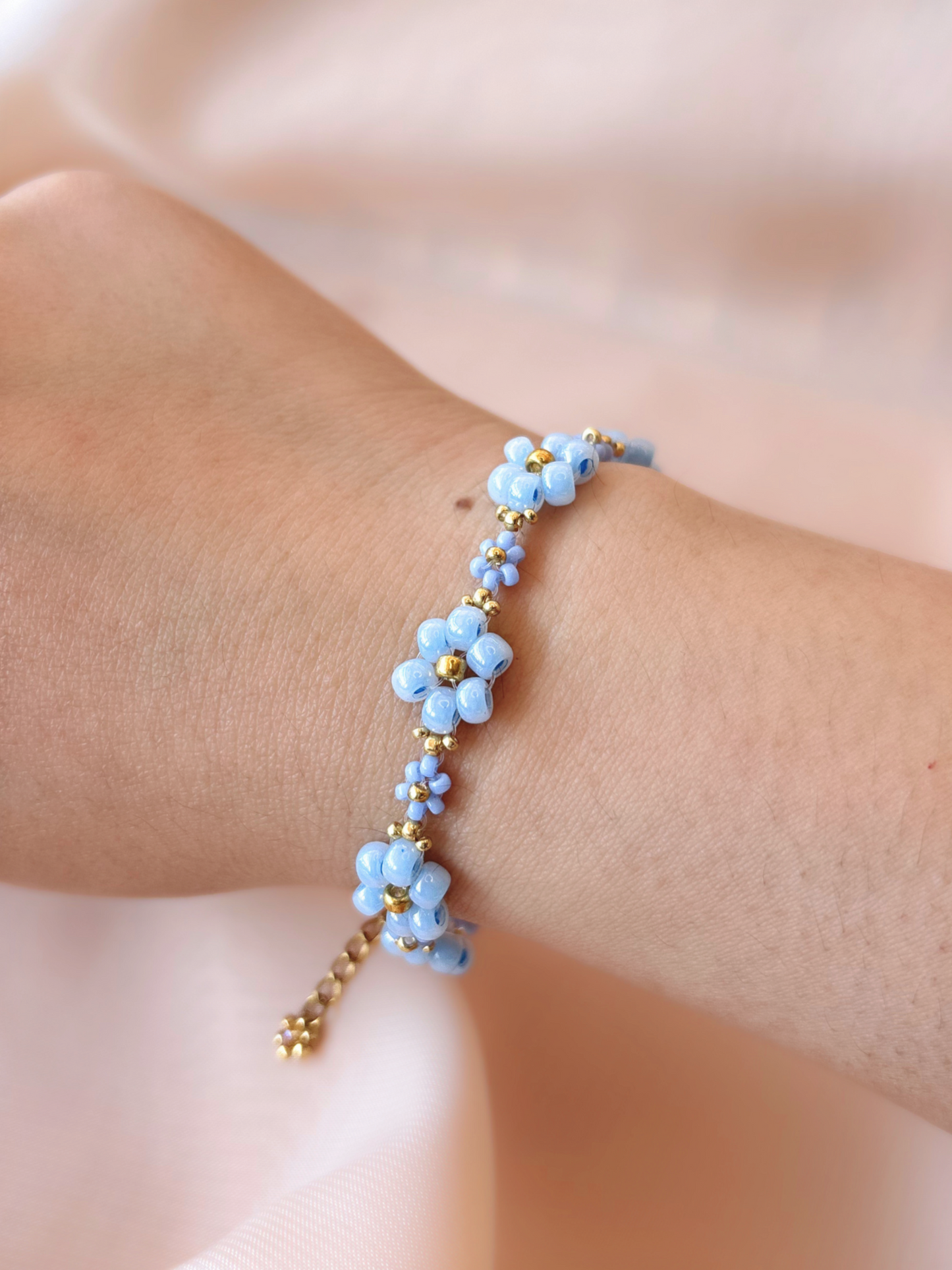 Dear Daisy Bracelet in Glass Slipper, featuring blue flower beads made of premium Japanese seed beads, shown worn on a wrist.