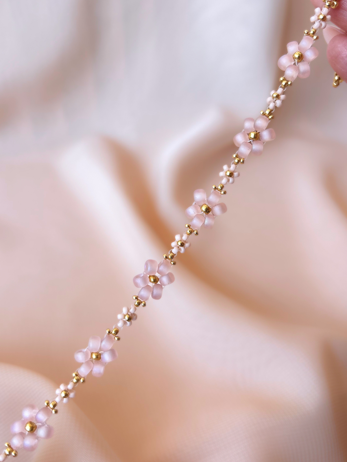 Close up of Dear Daisy Bracelet in First Kiss, showcasing premium Japanese seed bead pink blush flowers.