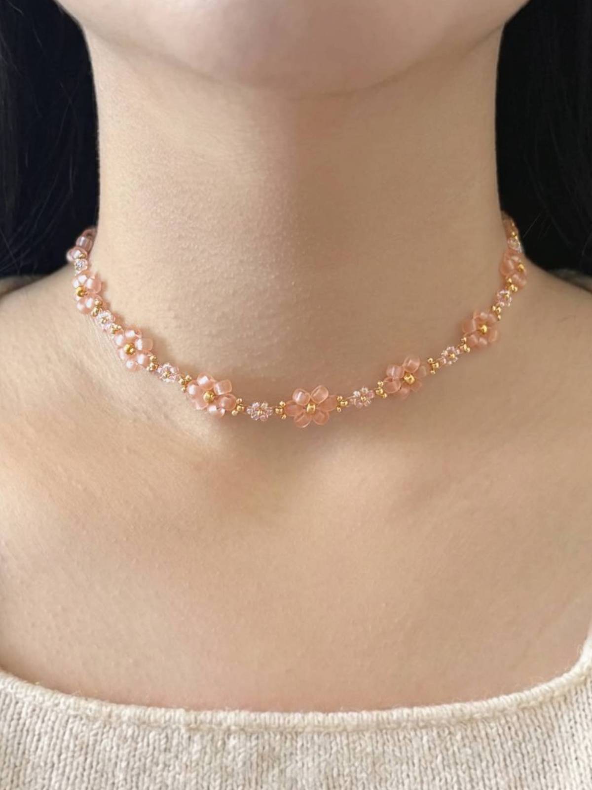 Dear Daisy Choker in First Kiss, featuring translucent pink flower beads made of premium Japanese seed beads, shown worn on a model's neck.