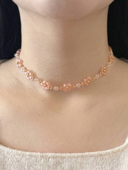 Dear Daisy Choker in First Kiss, featuring translucent pink flower beads made of premium Japanese seed beads, shown worn on a model's neck.