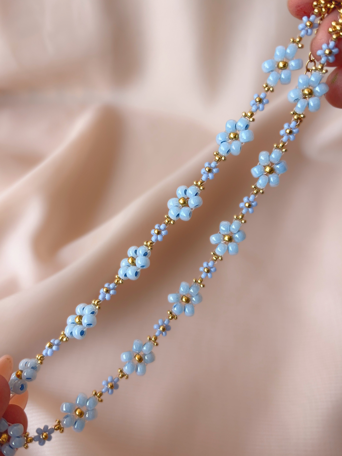 Close up of Dear Daisy Choker in Glass Slipper, showcasing blue flower designs made of premium Japanese seed beads.