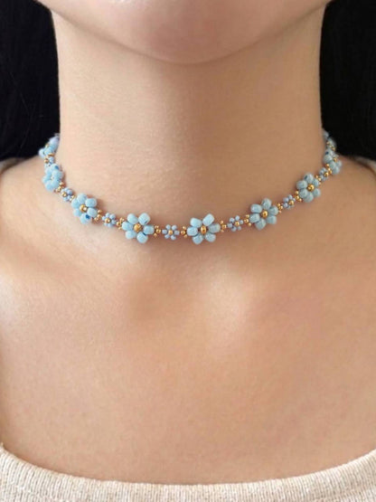 Dear Daisy Choker in Cloud Nine, featuring blue flower beads made of premium Japanese seed beads, shown worn on a model's neck.