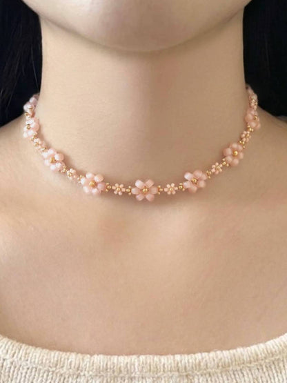 Dear Daisy Choker in First Kiss, featuring pink blush flower beads made of premium Japanese seed beads, shown worn on a model's neck.
