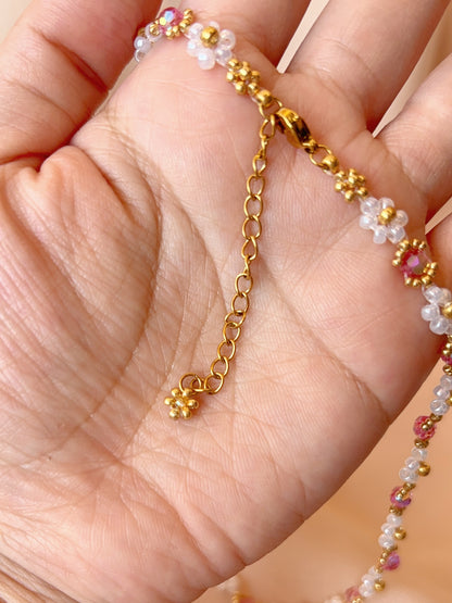 Close up of the dainty dangling gold daisy charm and adjustable extender chain on Wildflower Coquette choker.