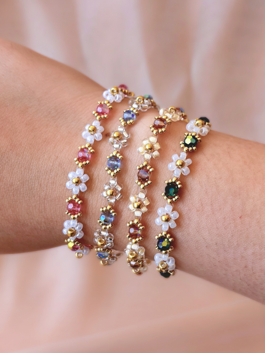 A stack of four Wildflower Coquette flower bracelets in all available colorways, showcasing the premium Japanese seed beads and sparkling Preciosa crystals on a wrist.