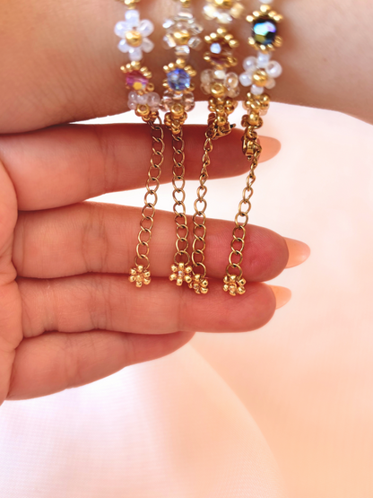 Close up of the dainty dangling gold daisy charm and adjustable extender chain on Wildflower Coquette bracelets.