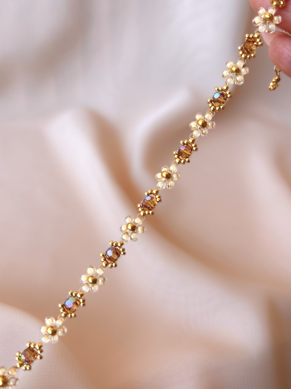 Close up of Wildflower Coquette bracelet in Gold Rush, showcasing premium Japanese seed bead daisies and topaz Preciosa crystal AB centers.