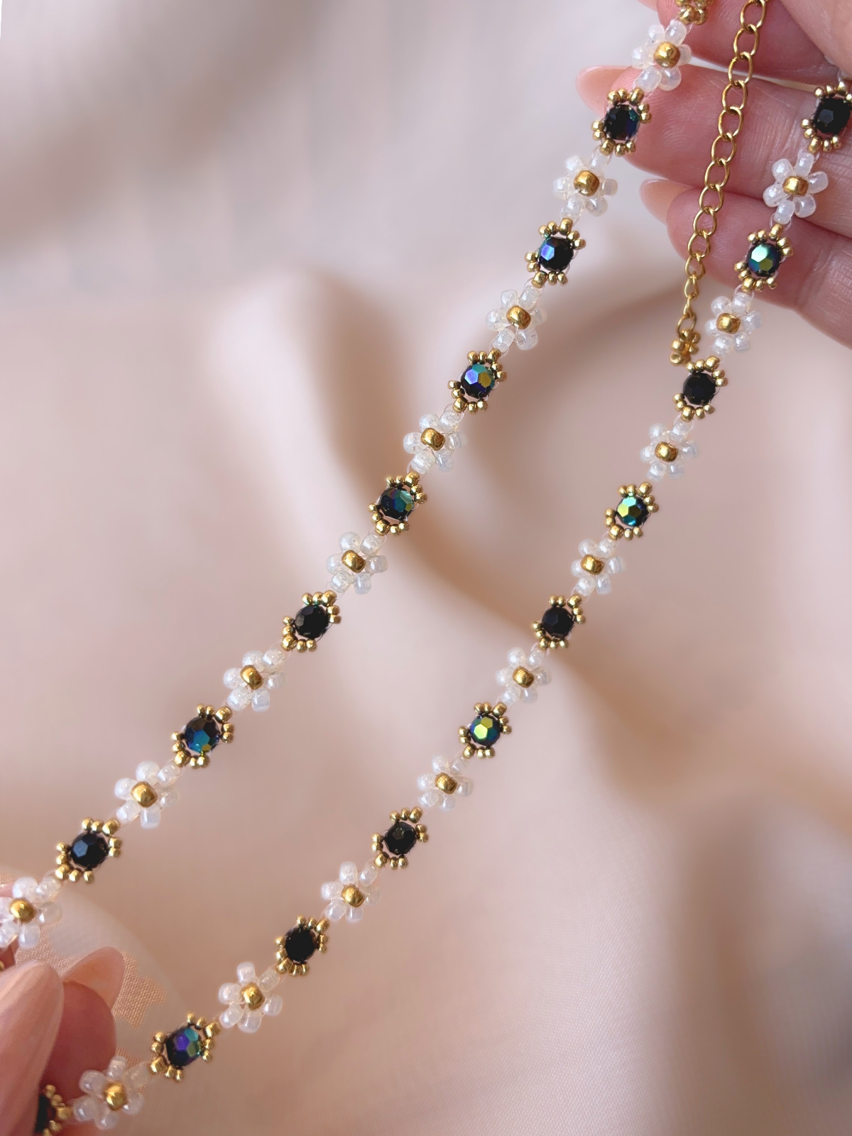 Close up of Wildflower Coquette Choker in Midnight Rain, showcasing premium Japanese seed bead daisies and black Preciosa crystals.