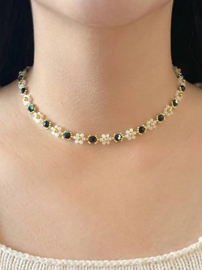 Wildflower Coquette Choker in Midnight Rain, made of premium Japanese seed bead daisies with black Preciosa crystal centers, shown worn on a model's neck.