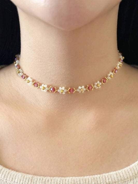 Wildflower Coquette Choker in Pinky Promise, made of premium Japanese seed bead daisies with pink Preciosa crystal centers, shown worn on a model's neck.