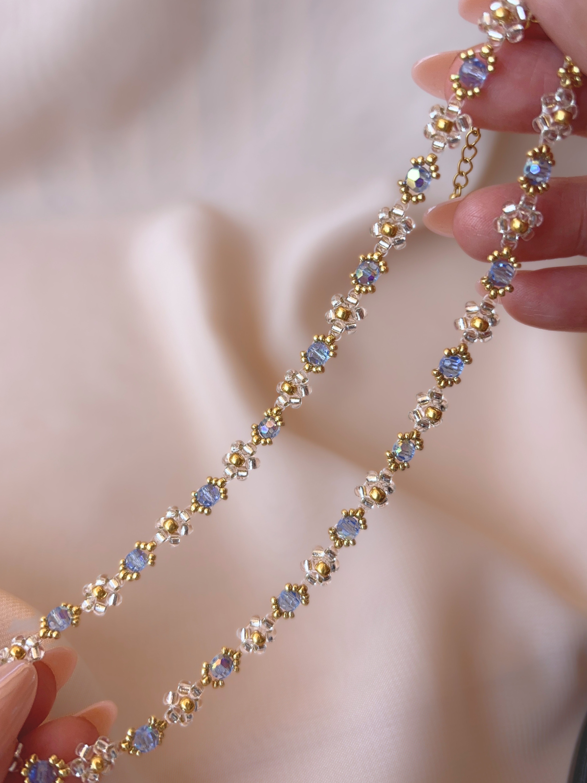 Close up of Wildflower Coquette Choker in Pixie Dust, showcasing premium Japanese seed bead daisies and blue Preciosa crystals.