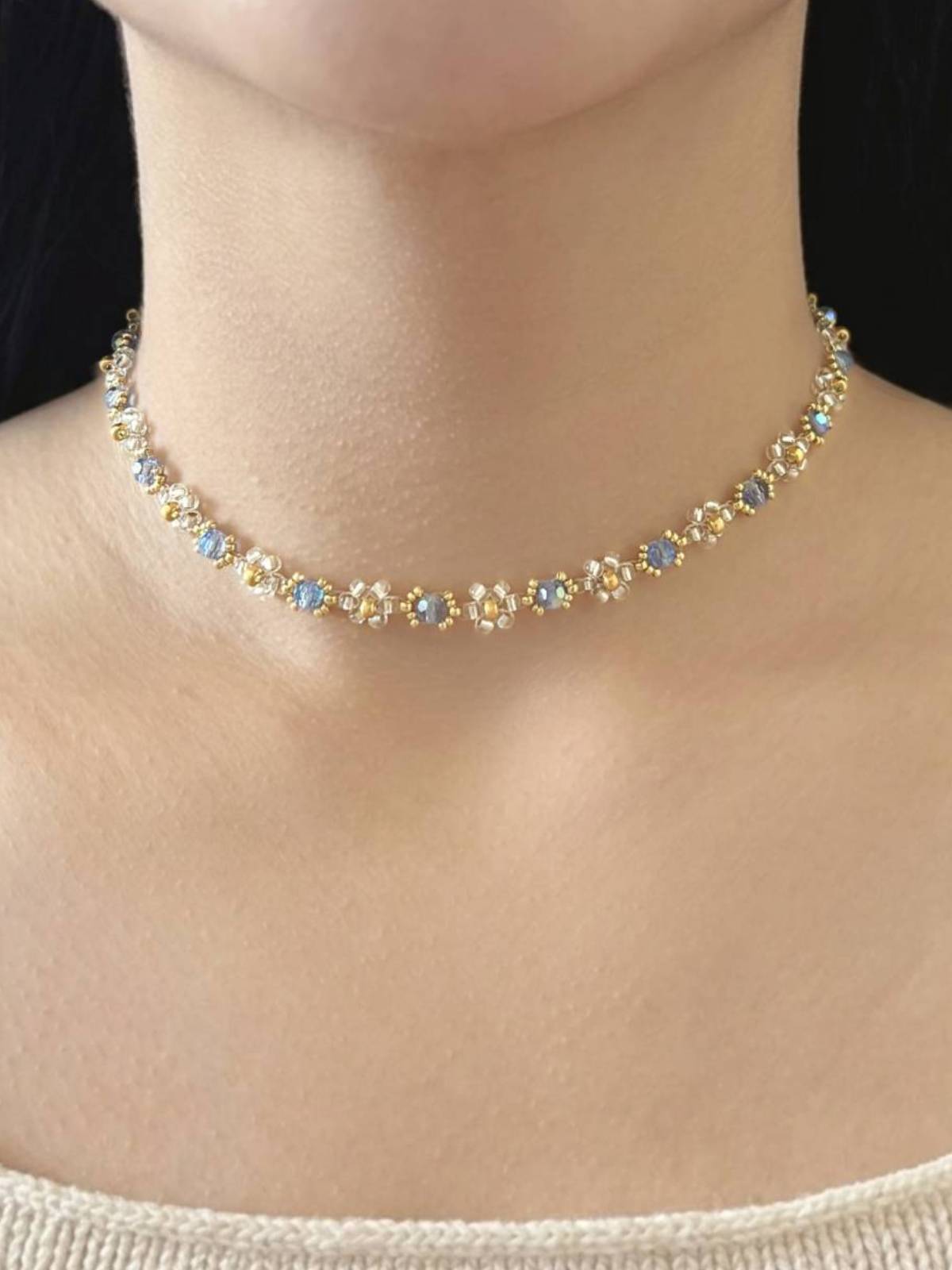 Wildflower Coquette Choker in Pixie Dust, made of premium Japanese seed bead daisies with blue Preciosa crystal centers, shown worn on a model's neck.